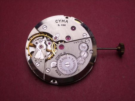 Uhrwerk Cyma Cal. 488, Handaufzug, Zentralsekunde, mit Datumsscheibe (schwarze/rote Schrift auf weißem Untergrund), signiert: Tavannes, NOS (New Old Stock) 
