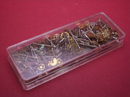 Sortiment aus verschiedenen Uhrenersatzteilen in Kunststoffbox 